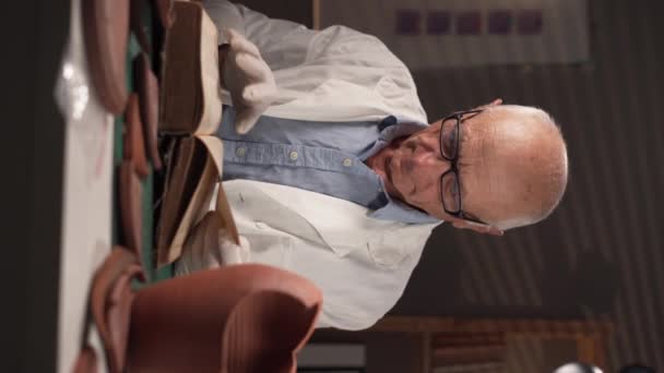 Egy Idős Férfi Régész Fehér Kabátban Kesztyűben Egy Asztalnál Irodában — Stock videók
