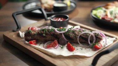 Lokantada tahta bir tahtanın üzerinde sıcak lula kebabı yiyen bir kadının yakın çekimi. Boşluğu kopyala