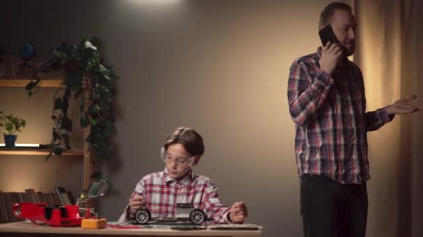 Ojciec Syn Naprawiają Zepsutą Zabawkę Wieczorem Mężczyzna Ignorujący Dziecko Komunikuje — Wideo stockowe