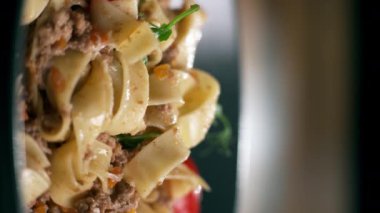 Restoranda etli makarna ve parmesan peyniri yiyen bir kadın, yakın plan. Dikey video