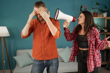 Evde kavga eden genç bir çift, hoparlörden kocasına bağıran kızgın bir eş. Sorunlu ilişkiler, aile içi şiddet ve boşanma kavramı. Boşluğu kopyala