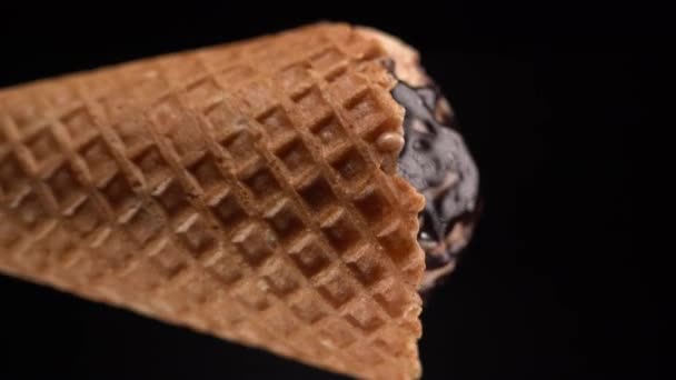 アイスクリームコーンと溶けたチョコレートトッピング ブラックバックで分離 夏のデザートコンセプト バーティカルビデオ — ストック動画
