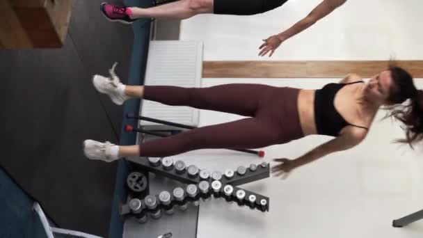 在体育馆里训练做手臂肌肉 俯卧撑和跳跃运动的妇女 垂直录像 — 图库视频影像