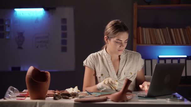 Kobieta Archeolog Przy Użyciu Laptopa Analizując Naczynia Gliniane Starożytnych Artefaktów — Wideo stockowe