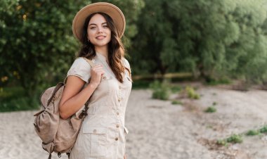 Akşamları kumsalda sırt çantalı bir turist kameraya bakıyor, gülümsüyor, dışarıda eğleniyor. Boşluğu kopyala