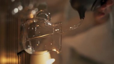 Çay töreni konsepti. Bir kadın çaydanlığa çay ile kaynar su döker. Yakın plan. Dikey video