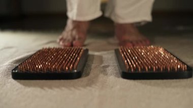 Meditasyon için keskin tırnaklara basan erkek ayaklarının yakın çekimi, sadhu tahta tahtası. Yoga pratiği konsepti. Boşluğu kopyala