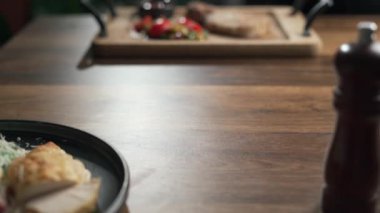 Kadın eli tabakta kızarmış balık kesiyor, yakın plan. Lokantada nefis pişmiş levrek yiyen tanınmayan bir kadın. Keto diyet kavramı