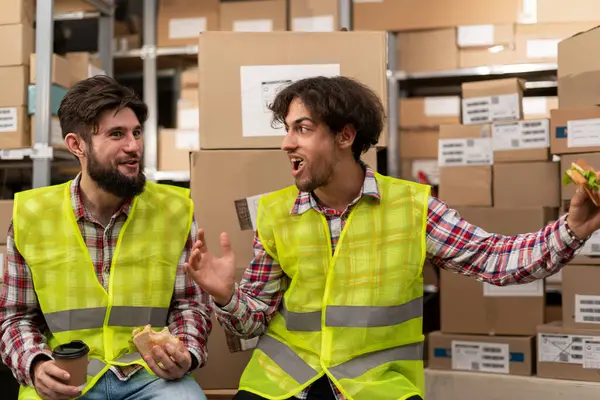 Young Warehouse Workers Have Lunch Talk Break While Sitting Workplace Stock Photo