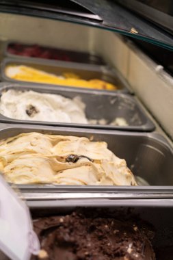 Kafe vitrinindeki buzdolabında sergilenen çeşitli İtalyan dondurmaları. Yakın plan.