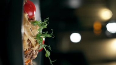 Parmesan peyniri ve domatesle süslenmiş biftek soslu lezzetli İtalyan makarnası yemek. Dikey video