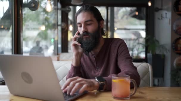 Freelancer Barbudo Cabelos Compridos Trabalhar Remotamente Num Café Chamada Telefónica — Vídeo de Stock