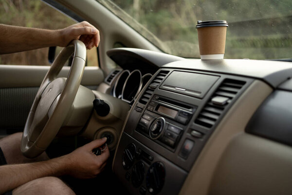 Мужчина рукой вставляет ключ от машины в замочную скважину и заводит машину. Копирование пространства