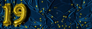 19 numara, altın folyo balon numarası mavi kadife arka planda konfetili. Doğum günü tebrik kartı, 19. yazı. Yıldönümü etkinliği. Pankart. Şık altın rakamlı, parlak parlak bir ışık. Boşluğu kopyala,