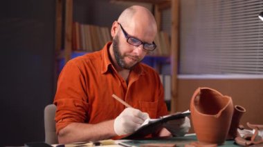 Gece geç saatlere kadar çalışan sakallı erkek arkeolog masa başında fazla mesai yaparken panoya veri yazıyor. Boşluğu kopyala