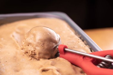 Dondurma konteynırdan özel bir kepçeyle alınır. Yakın plan.