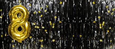 Siyah süslemenin arka planında 8 numaralı altın folyo balonu. Doğum günü tebrik kartı, sekiz harfli. Yıldönümü etkinliği. Pankart. Boşluğu kopyala.