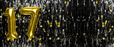 17 numaralı altın folyo balon siyah süsleme arka planında. Doğum günü kartı, onyedinci yazı. Yıldönümü etkinliği. Pankart. Boşluğu kopyala.