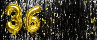 Siyah süslemenin arka planında 36 numaralı altın folyo balonu. Doğum günü tebrik kartı, yazıt 36. Yıldönümü etkinliği. Pankart. Boşluğu kopyala.