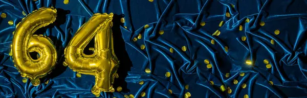 Gold foil balloon number number 64 on a background of blue velvet decoration. Birthday greeting card, inscription sixty-four. Anniversary event. Banner. Copy space