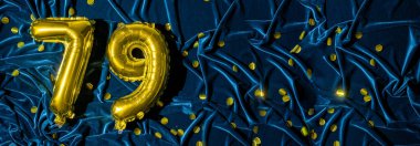 Mavi kadife dekorasyonun arka planında 79 numaralı altın folyo balonu. Doğum günü tebrik kartı, 79. yazı. Yıldönümü etkinliği. Pankart. Boşluğu kopyala