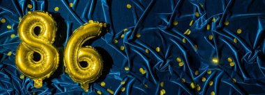 86 numaralı altın folyo balonu. Doğum günü ya da yıldönümü kartında 86. Mavi kadife arkaplan yazıyor. Yıldönümü kutlaması. Pankart. Boşluğu kopyala