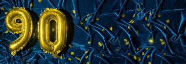 90 numaralı altın folyo balonu. 90 yazılı doğum günü ya da yıldönümü kartı. Mavi kadife arka plan. Yıldönümü kutlaması. Pankart. Boşluğu kopyala