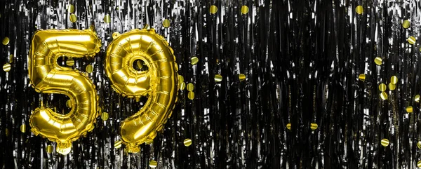 Gold foil balloon number number 59 on a background of black tinsel decoration. Birthday card, inscription fifty-nine. Anniversary event. Banner. copy space.