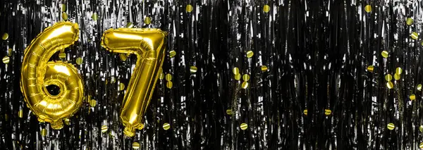 Gold foil balloon number number 67 on a background of black tinsel decoration. Birthday greeting card, inscription sixty-seven. Anniversary event. Banner. copy space.