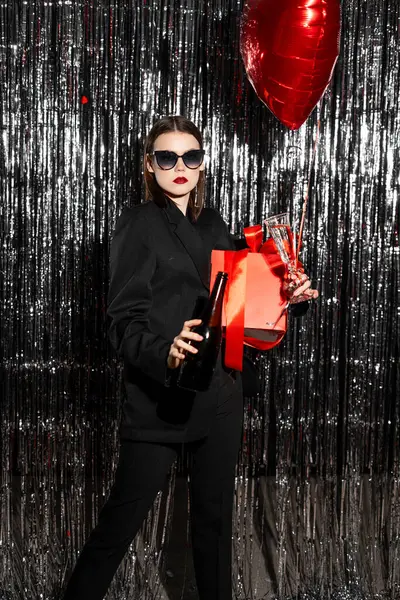 Valentines Day Party. Stylish woman with red heart ballon on tinsel background. Copy space. Copy space