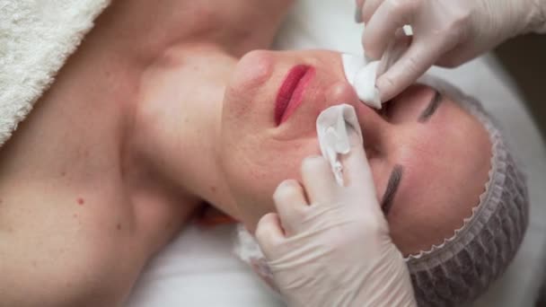 Kosmetikerin Wischt Einer Entspannten Frau Wellness Salon Feuchtigkeitsspendende Maske Mit — Stockvideo