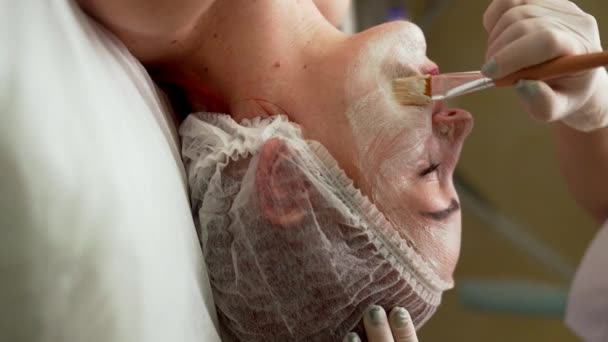 Cosmetologist Dermatologista Aplicando Máscara Para Tratamento Facial Para Mulher Deitada — Vídeo de Stock