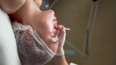 Güzellik uzmanının güzellik salonundaki hastaya kimyasal kabuk tedavisi uyguladığı yakın çekim. güzellik tedavi konsepti.