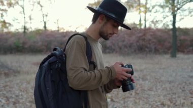 Sonbahar ormanlarında profesyonel bir kamerayla doğayı fotoğraflayan bir fotoğrafçı. Boşluğu kopyala
