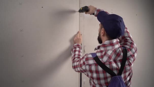 Trabalhador Construtor Macacão Azul Instala Drywall Gesso Uma Construção Usa — Vídeo de Stock