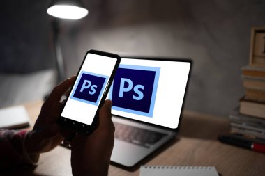 Odessa, Ukrayna, 13 Ocak 2023: Akıllı telefon ve dizüstü bilgisayarda Photoshop logosu. Photoshop, Adobe tarafından geliştirilen bir raster grafik düzenleyici yazılımdır. Boşluğu kopyala