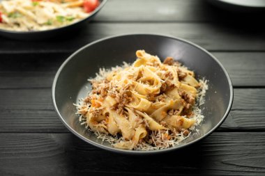 Bolonez soslu İtalyan makarnası. Masada çeşitli tabaklar var. Boşluğu kopyala