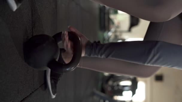年轻女子在体育馆里做运动时 带着水壶铃铛 垂直录像 — 图库视频影像