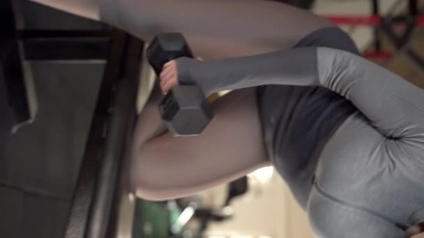 Close Fitness Woman Lifting Dumbbell While Leaning Bench Gym Vertical — Stock Video