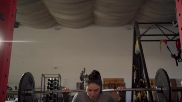 女健美运动员带着沉重的杠铃进行运动 女子蹲在体育馆里锻炼 举重锻炼 复制空间 — 图库视频影像