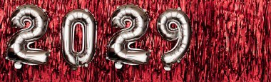 Kırmızı arka planda 2029 rakam balonları. Yeni yıl kompozisyonu. Pankart