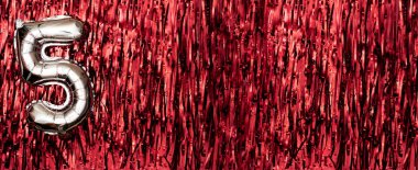 Kırmızı arka planda beş numaralı gümüş folyo balonu. 5. yaş günü kartı. Yıldönümü konsepti. Doğum günü, yeni yıl kutlaması. Pankart. Boşluğu kopyala