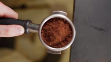 Barista ya da kahve makinesi portafilter tutuyor ve kahve dolduruyor kafe ya da restoranda espresso yapıyor, yakın plan.