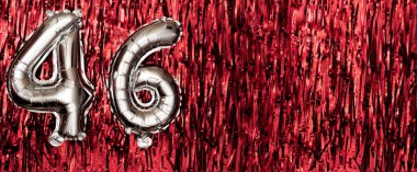 Kırmızı süslemenin arka planında 46 numaralı gümüş folyo balonu. Doğum günü tebrik kartı, 46. yazıt. Yıldönümü etkinliği. Pankart. Boşluğu kopyala.