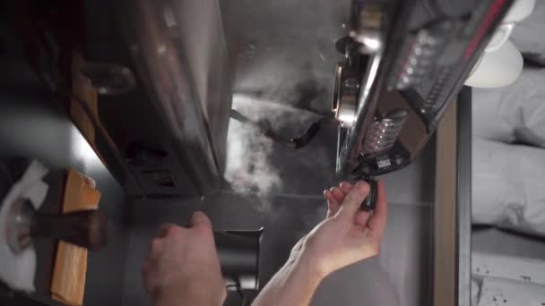 コーヒーマシンを使用してメニューにミルクを蒸すバリスタ カフェで新鮮なコーヒーを準備するコーヒーマシン バーティカルビデオ — ストック動画