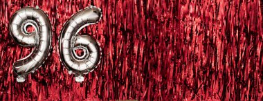96 numaralı gümüş folyo balonu. Doğum günü ya da yıldönümü kartı. Altında 96 yazılıydı. Kırmızı süsleme. Yıldönümü kutlaması. Pankart. Boşluğu kopyala