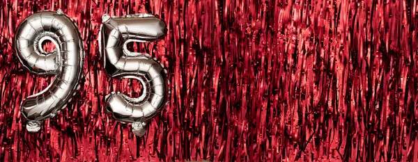 Silver foil balloon number ninety-five. Birthday or anniversary card with the inscription 95. red tinsel background. Anniversary celebration. Banner. copy space