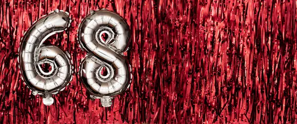 Silver foil balloon number, digit sixty-eight on red background. Birthday greeting card with inscription 68. Anniversary celebration event. Banner. Numerical digit. Copy space