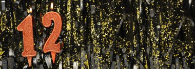 Işıltılı arka planda kırmızı doğum günü mumları yakmak, 12 numara. Pankart. Boşluğu kopyala