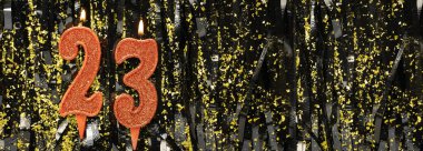 Işıltılı arka planda kırmızı doğum günü mumları yakmak, 23 numara. Pankart. Boşluğu kopyala